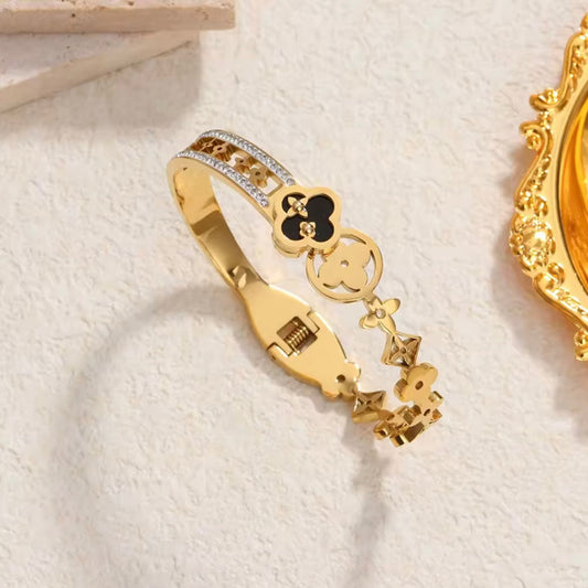 Gold bracelet with decorative elements on a light background