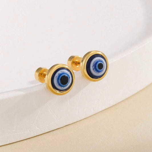 Gold stud earrings with blue eye design on a white surface