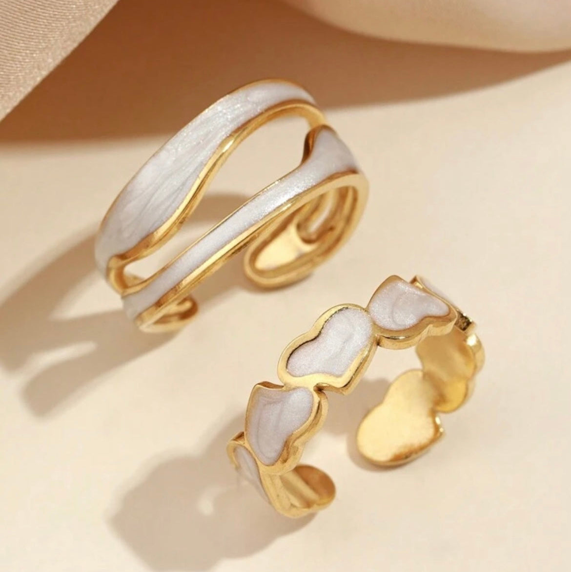 Gold and white rings on a beige background