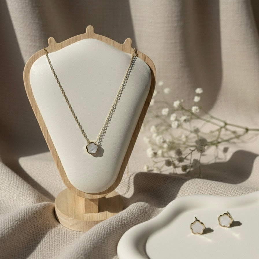 Necklace on a white cushioned stand with earrings on a beige surface