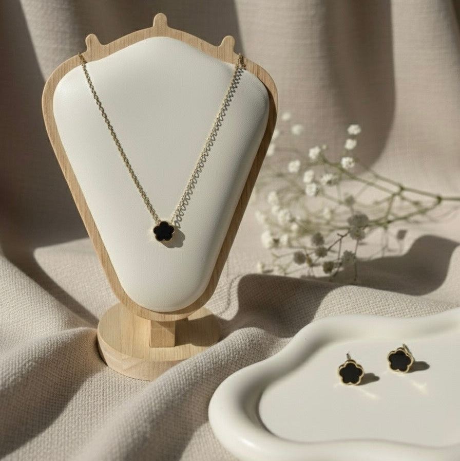 Necklace and earrings on a white cushion with a beige background