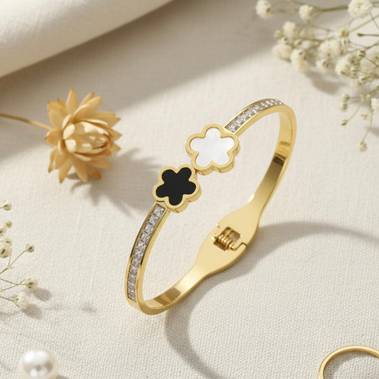 Gold bracelet with floral design on a light background